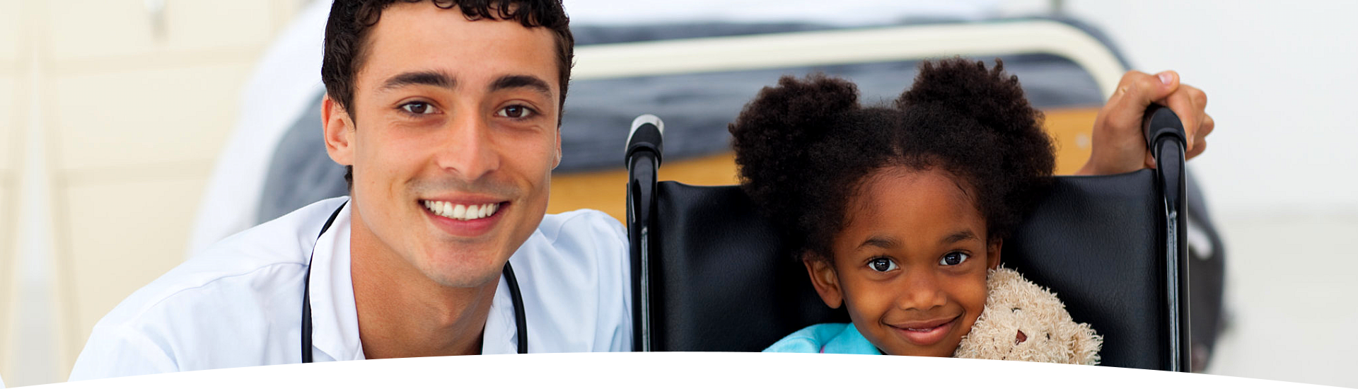 doctor sitting beside a child in a wheelchair
